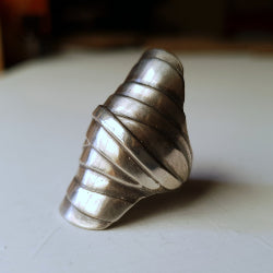 large silver ring consisting of many wrap over ribbons like a mummy